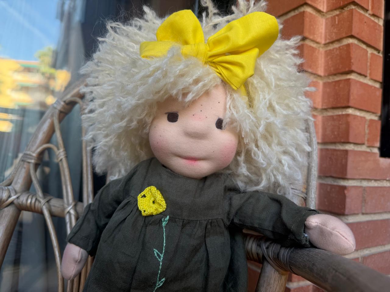 Primer plano de la muñeca del moño amarillo, con pecas y mejillas rosadas.